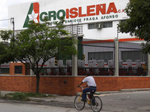 Un ciclista pasa por un centro de distribución de AgroIsleña (Globovisión)