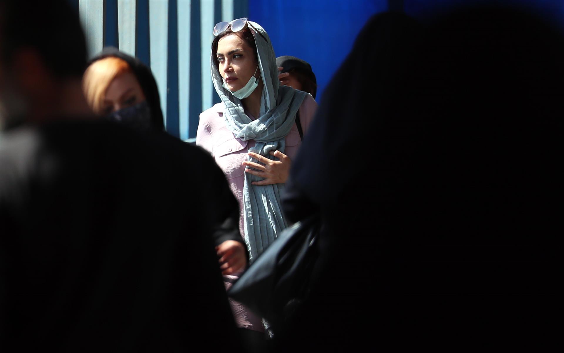 Teherán (Irán), 19/09/2022.- Mujeres iraníes pasan por una calle, en Teherán, Irán, este lunes. Las protestas estallaron en Saqez, ciudad natal de Amini, durante su funeral el 17 de septiembre. EFE/ABEDIN TAHERKENAREH